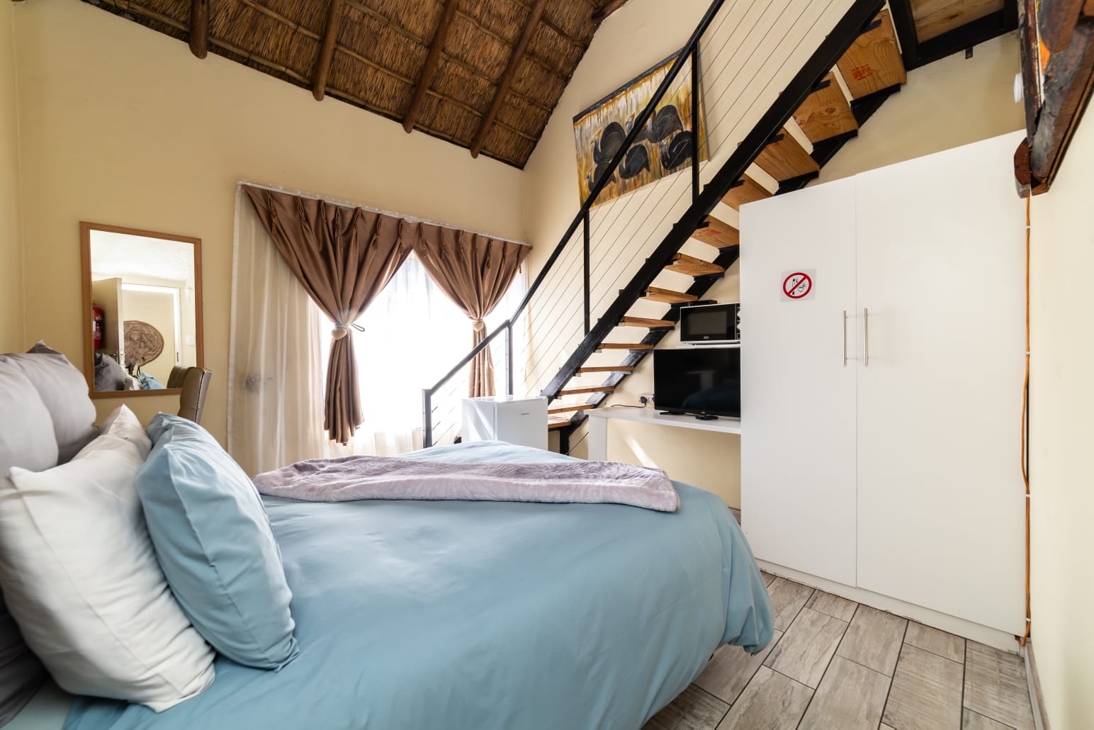 Cape Room 2 at Thatch Haven Guesthouse Centurion with double bed and thatch roof