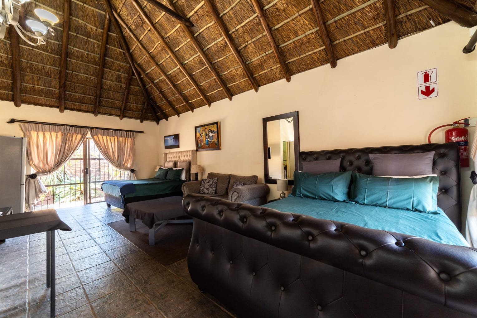 VIP Room 1 at Thatch Haven Guesthouse Centurion with high thatch roof and queen-sized bed
